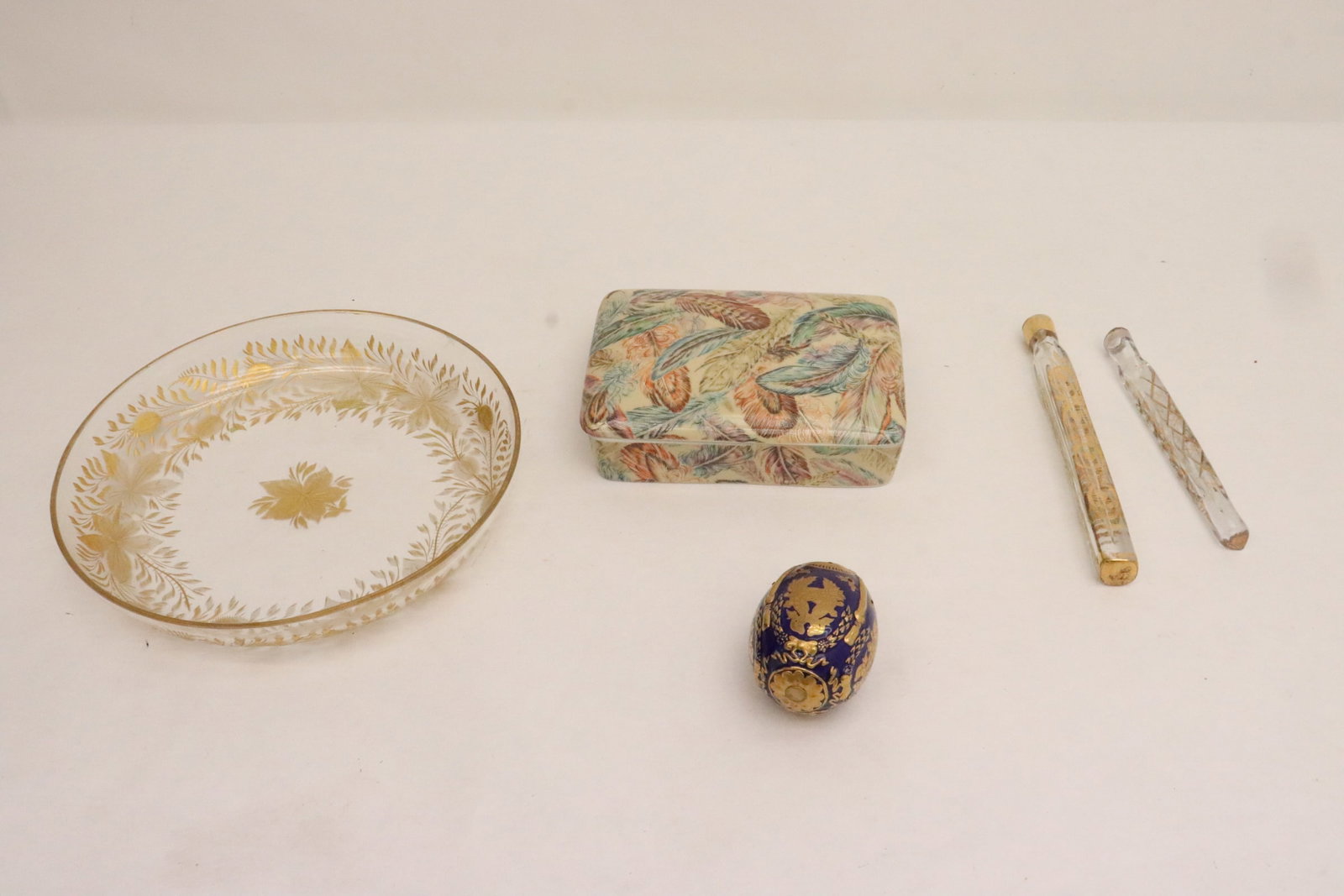 5 pieces: 5 pieces; antique French etched and gilt crystal plate (1.4"x8.2"dia), and 2 French antique etched and gilt scent bottle (no top) (5.75"L, 6.9"L), an enamel egg (2.75"x1.85"dia), and a porcelain box b