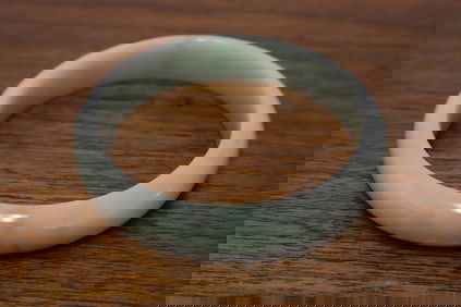 A natural color light apple green jadeite bangle