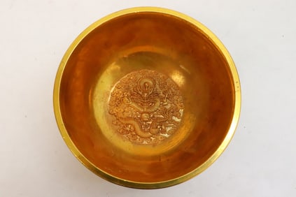 A gilt metal bowl with decoration in relief