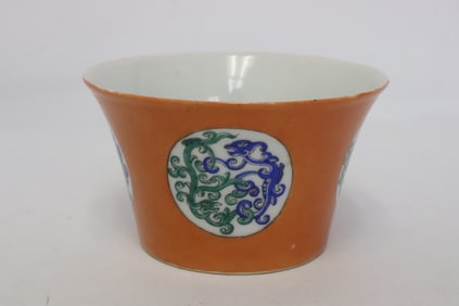 An orange background famille rose porcelain tea cup