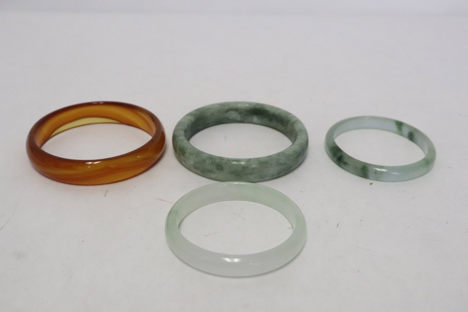 3 jadeite like bangles, & a Peking glass bangle: 4 pieces; 3 jadeite like bangles (0.33"x2.32"x2.6" - 0.52"x3"dia), and a Peking glass bangle (0.6"x3"dia)