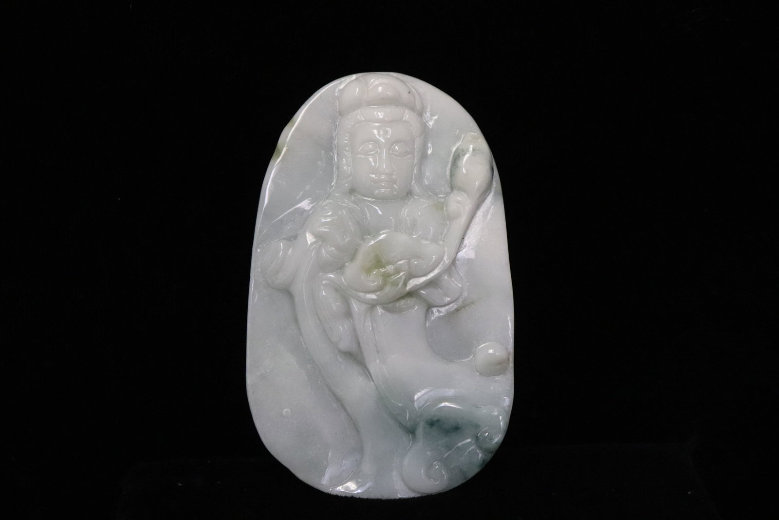 A jadeite carved plaque: A jadeite carved plaque depicting deity motif in relief, 0.3"x2.6"x1.6"
