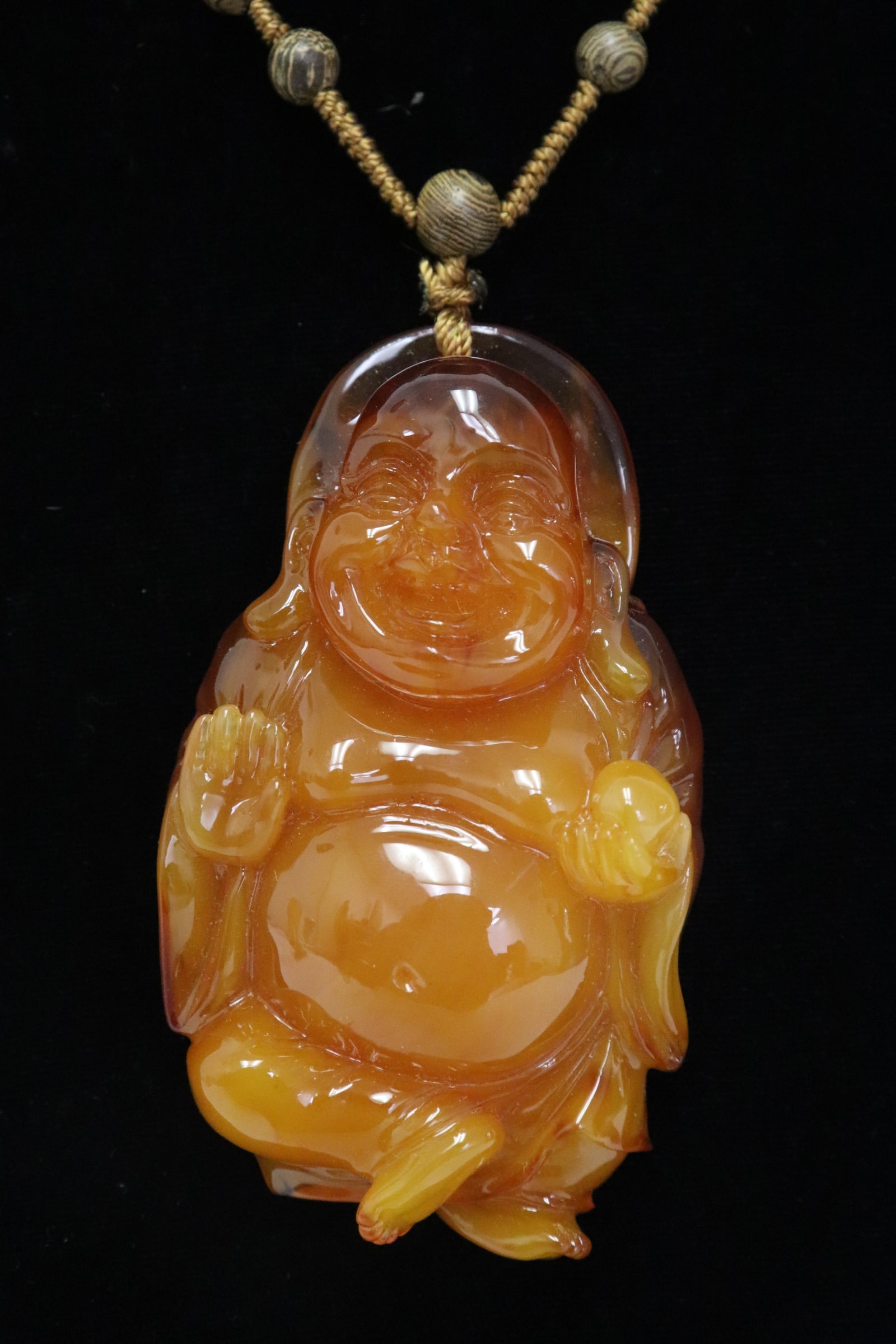 A simulated amber deity with necklace: A simulated amber deity (3.3"x1.83"x0.84") with necklace (21.4"L)