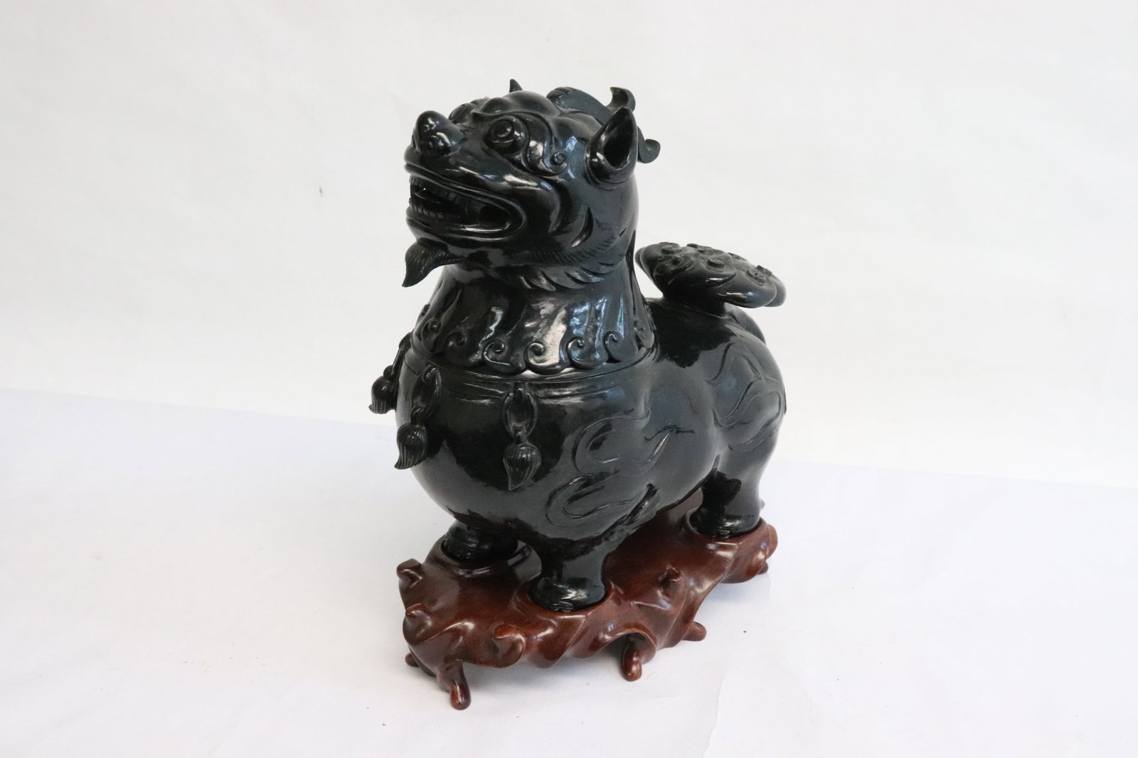 A dark green jade like stone carved censer: A dark green jade like stone carved censer in the form of qilin, 6.95"H