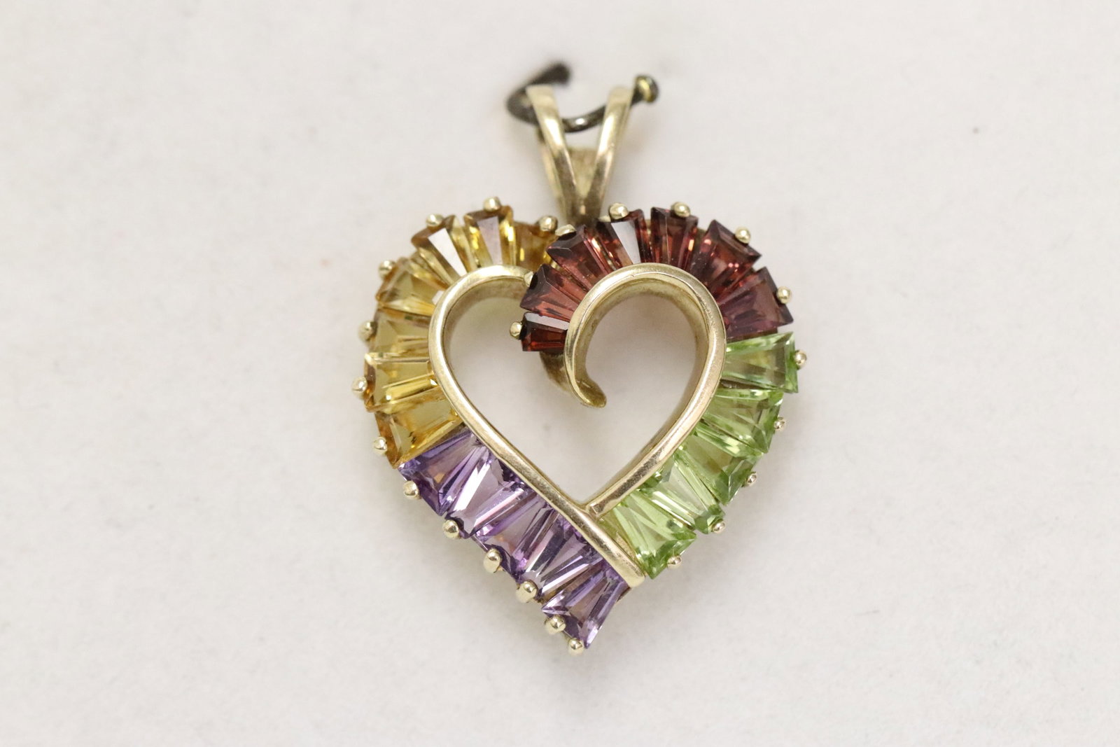 A 10K pendant set with color stones: A 10K heart shape pendant (1.1"x0.88") set with color stones, wt. 3.3gm