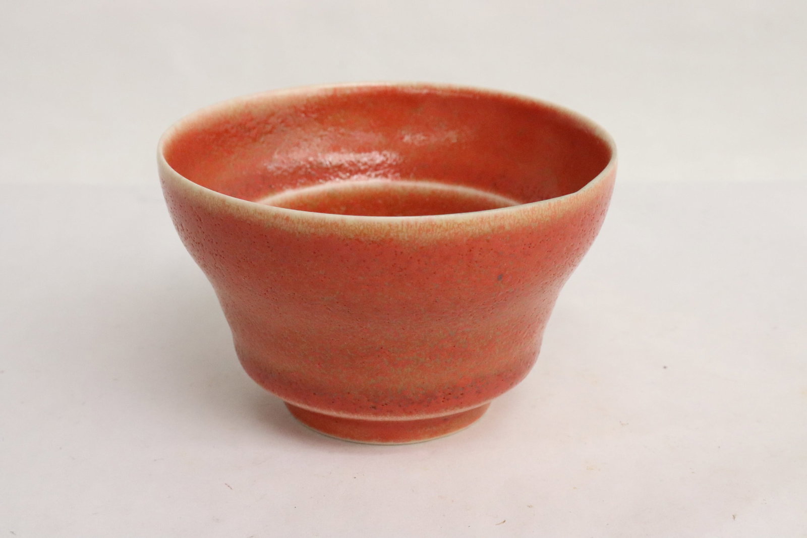 An orange glazed porcelain tea cup: An orange glazed porcelain tea cup, 2.3"x10.7"dia