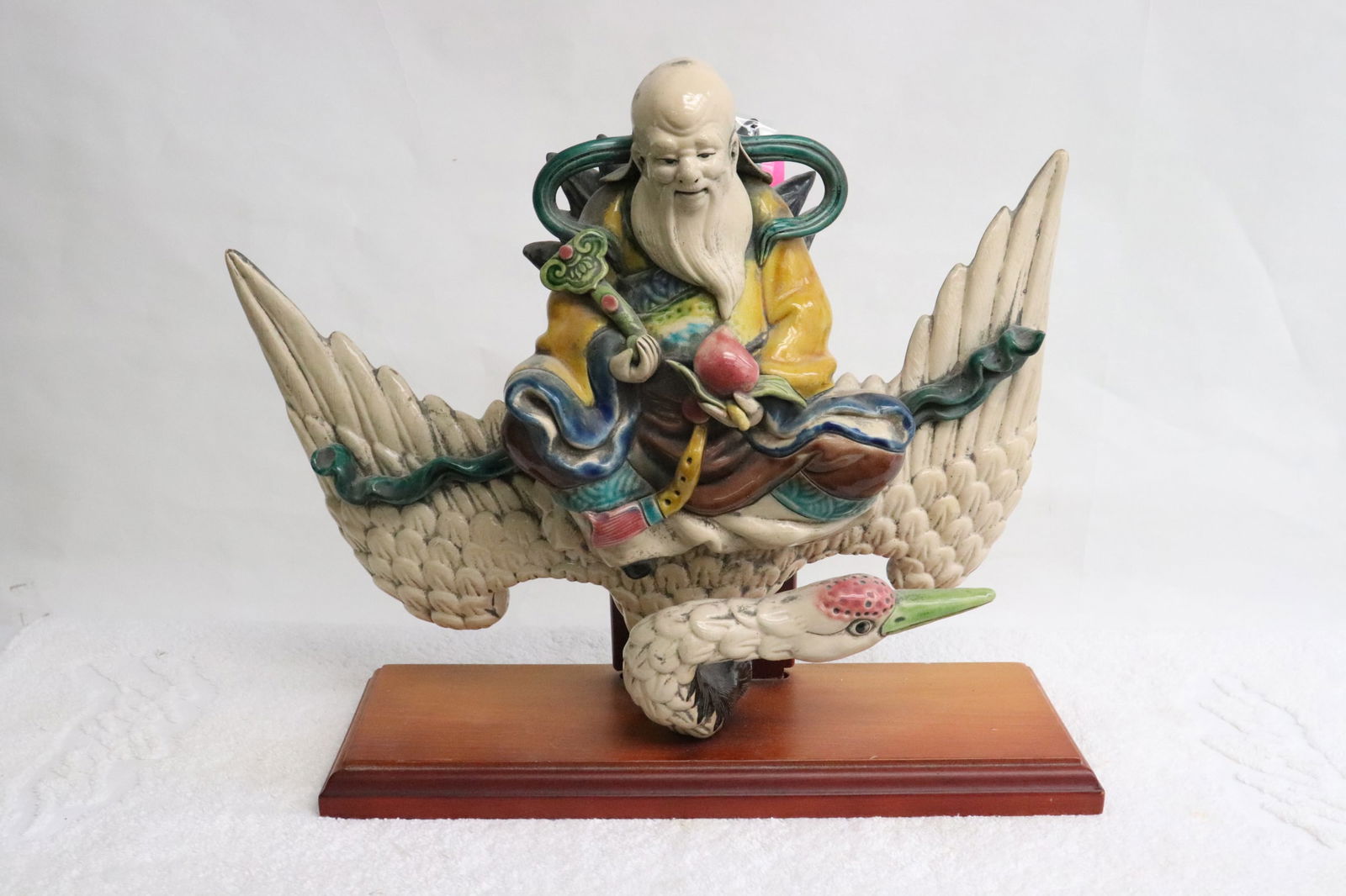 Chinese vintage roof tile mounted on wood stand: Chinese vintage roof tile (11.35"H) mounted on wood stand, depicting deity riding on crane