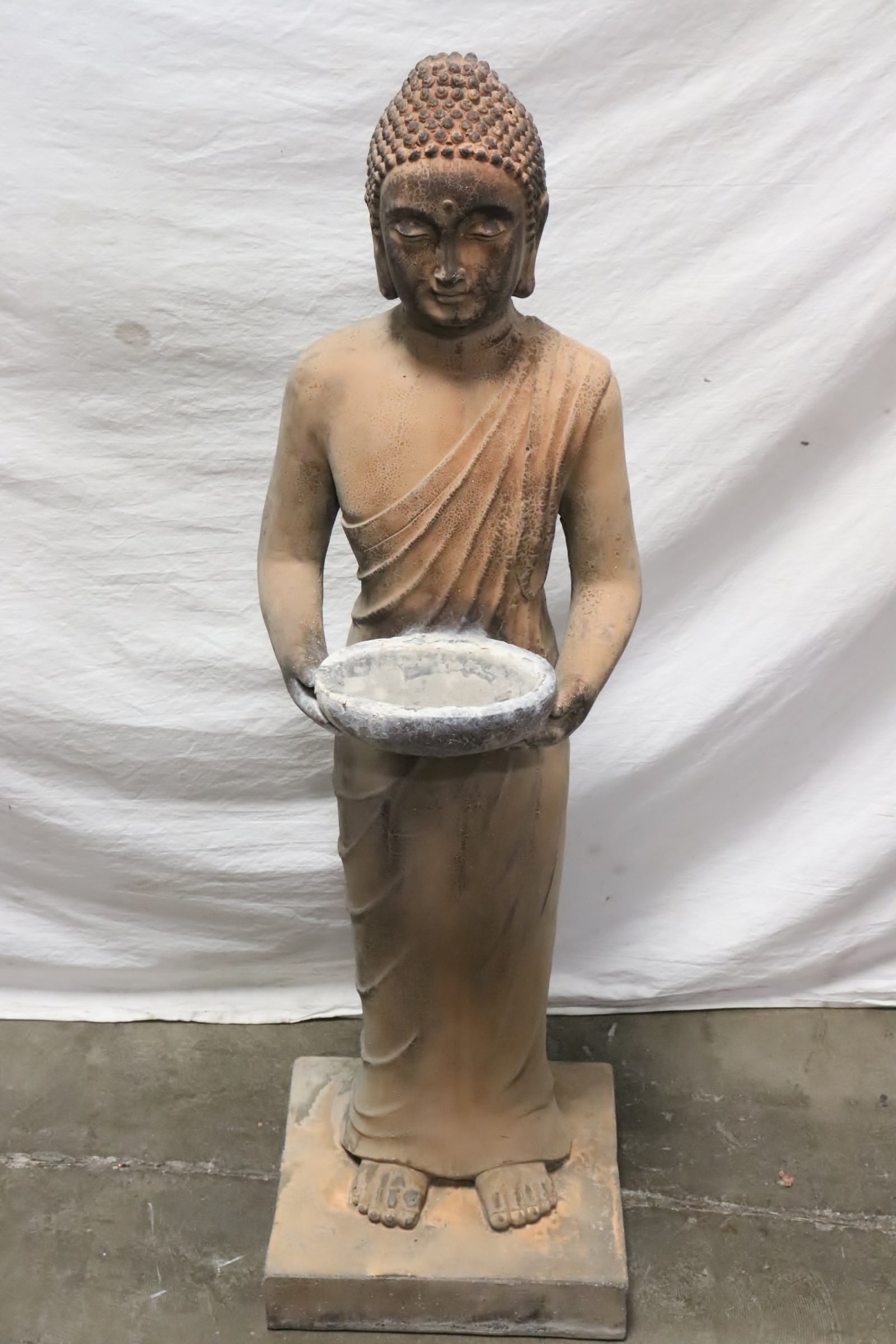 Terracotta sculpture of standing Buddha: Terracotta sculpture of standing Buddha holding an offering bowl, 39.15"H