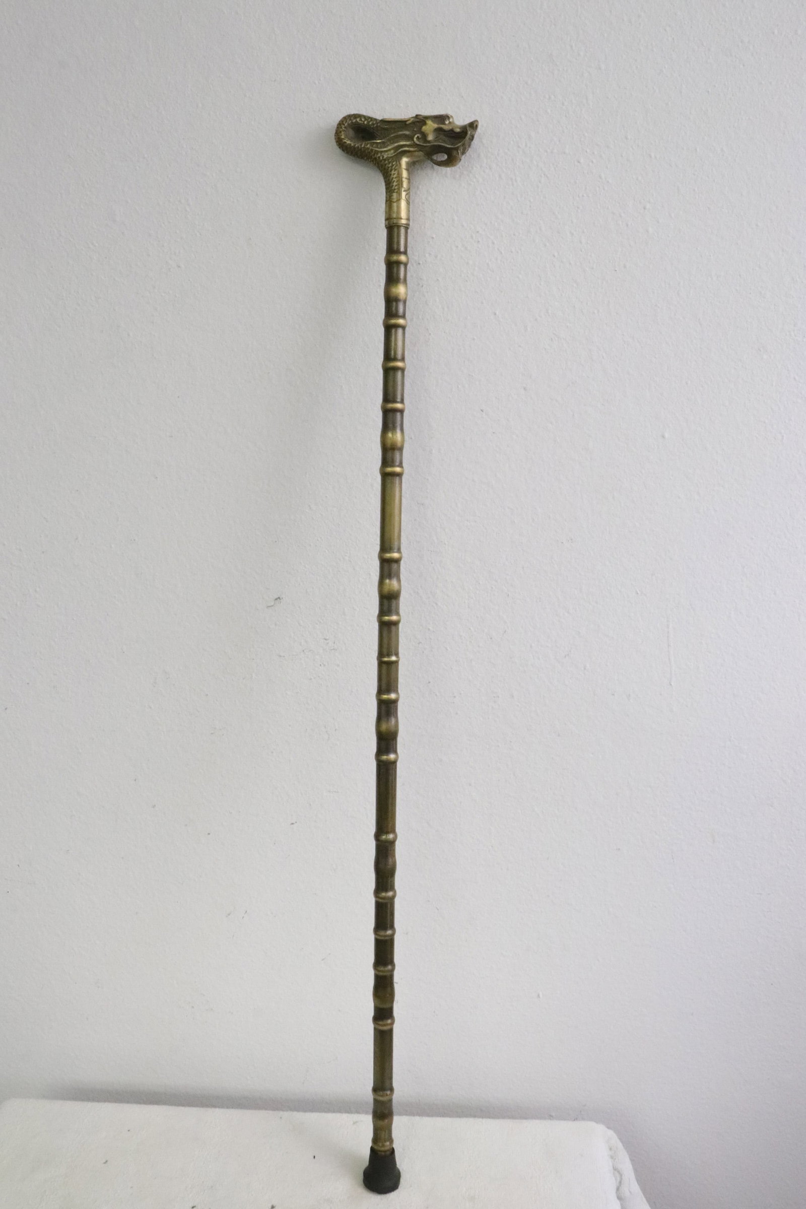 A bronze/ brass cane with dragon motif finial: A bronze/ brass cane with dragon motif finial, 35.7"L
