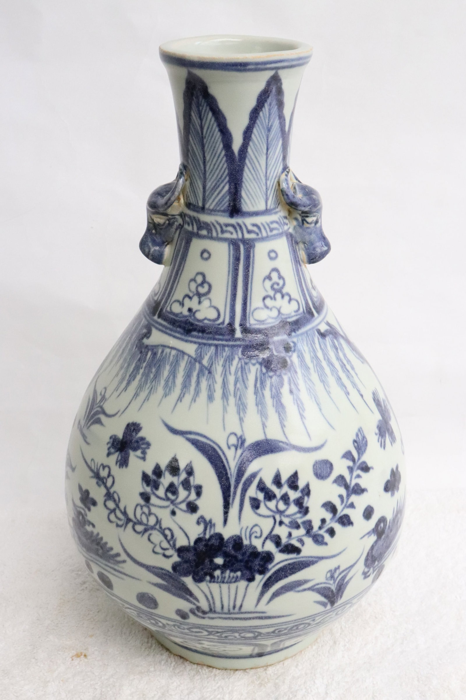 Blue and white porcelain vase: Blue and white porcelain vase with flower motif decoration, and with ball motif handles, 12.8"x7.5"dia