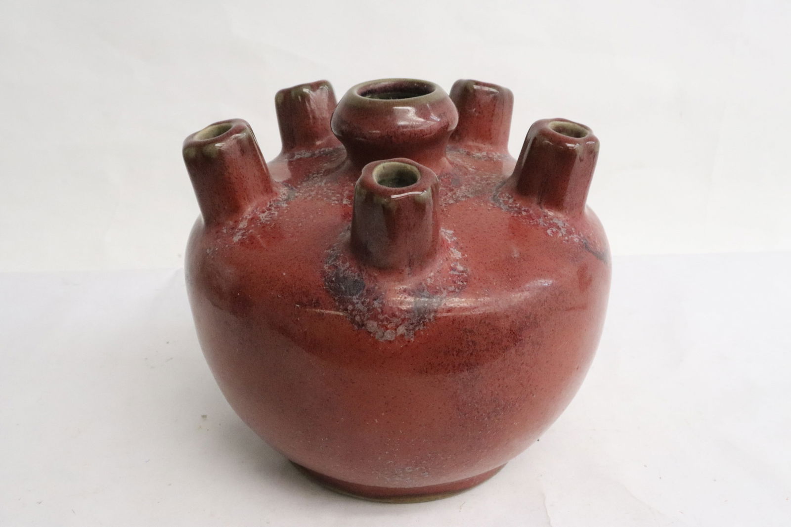 A red glazed multi-hole porcelain vase: A red glazed multi-hole porcelain vase, 4.75"x8.15"dia