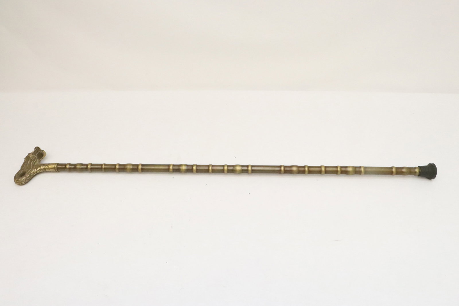 A bronze cane with dragon motif handle: A bronze cane with dragon motif handle, 35.6"L