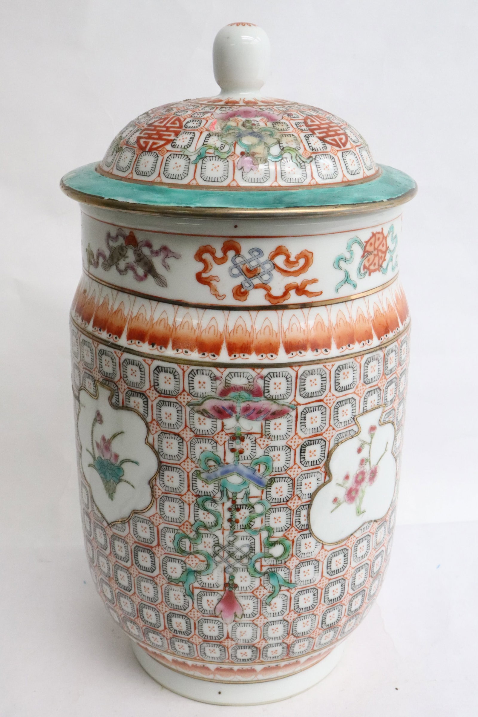 Chinese famille rose porcelain covered jar: Chinese famille rose porcelain covered jar, center panel decorated with flowers, body with geometric pattern, top rim with 8 treasure items, 12.15"x6.2"dia
