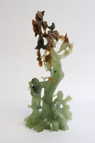 serpentine sculpture depicting people under tree