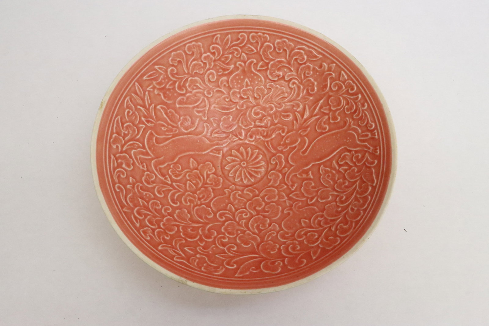 A pink glazed porcelain bowl: A pink glazed porcelain bowl embossed with floral motif decoration, 2.35"x8"dia