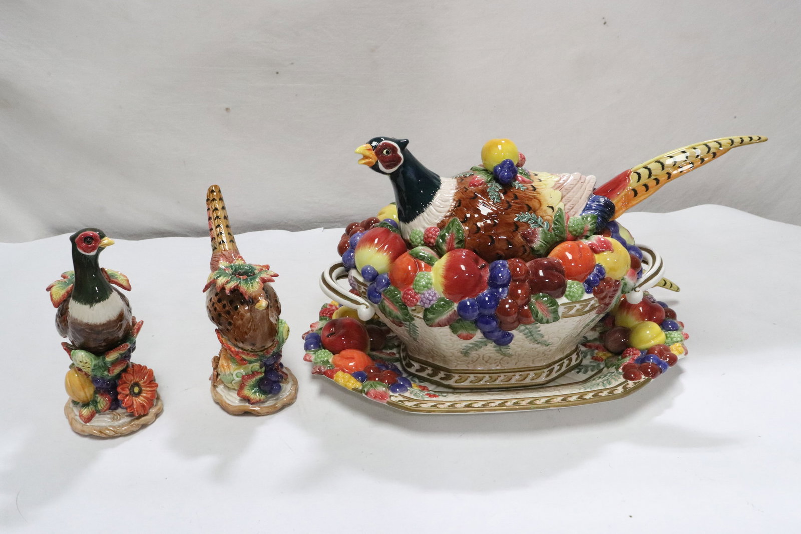 covered tureen w/ ladle & underplate, & 2 candle holders: A covered tureen (9.8"x17.6"x9.4") with ladle in the form of peasant with underplate (2.2"x16.4"x11.6"), and 2 candle holders (7.65"x6.7"x3.5", 8.3"x8.3"x3.7")