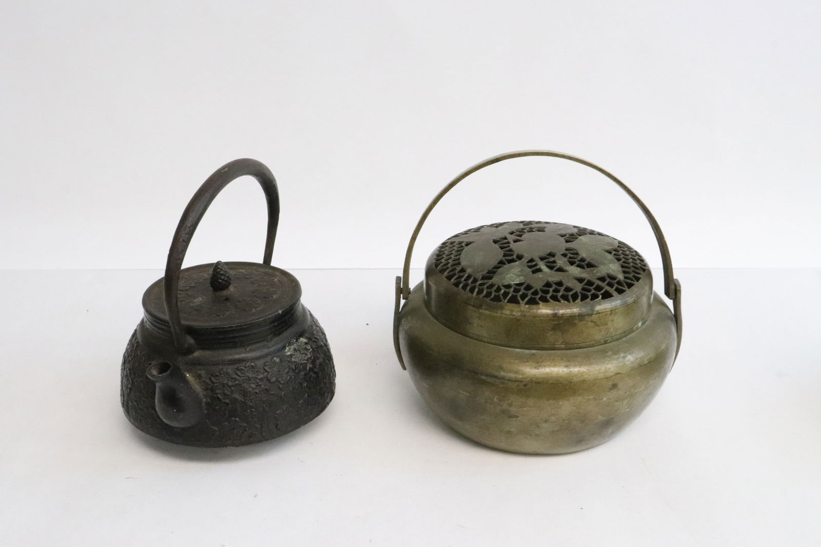 a cast iron teapot, & a brass handled hand warmer: 3 pieces; 2 cast iron teapot (3.25"x4.45"x4"), and a brass handled hand warmer (3.3"x5.4"x5.25")