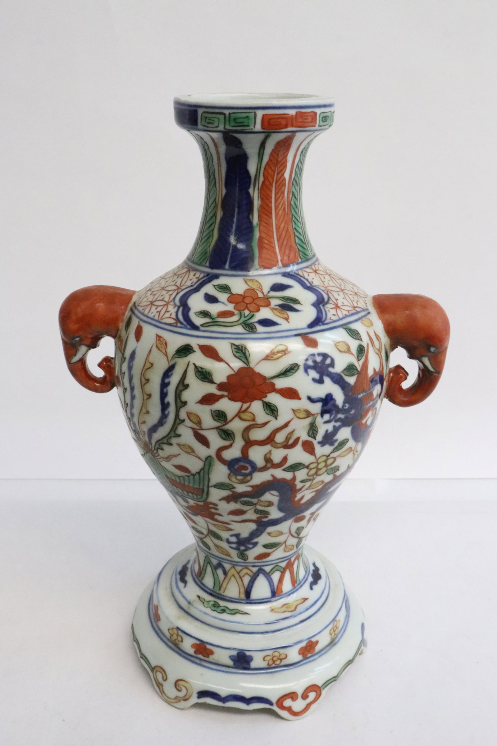 A wucai porcelain footed vase: A wucai porcelain footed vase decorated with dragon and phoenix on body, and with elephant motif handles, 9.6"x6"x4.3"