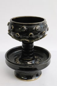 A brown glazed earthenware oil lamp