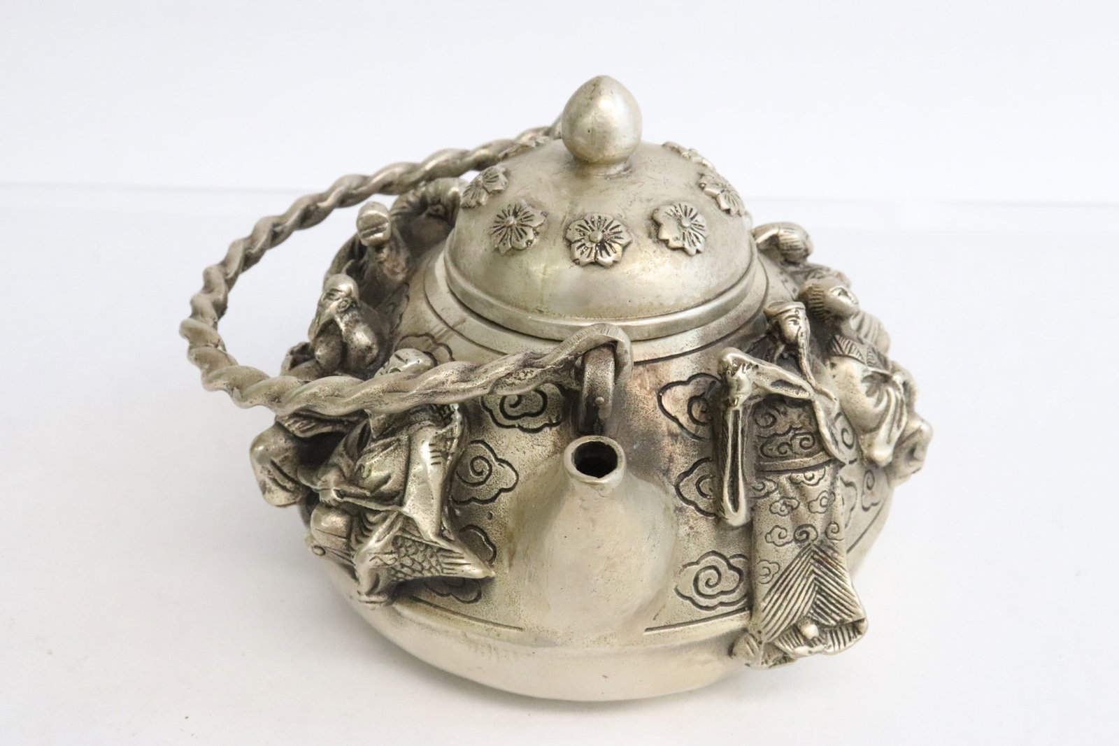 A white bronze teapot with deity motif in relief: A white bronze teapot with deity motif in relief, 3.8"x4.7"x4.4"