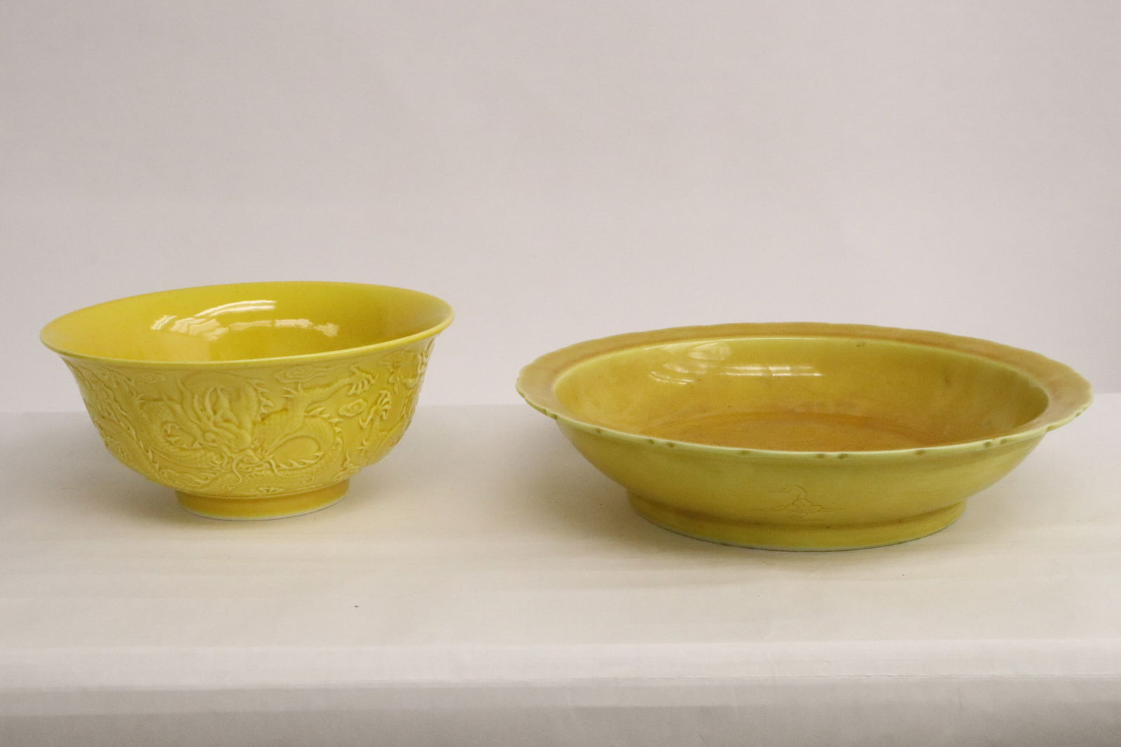 2 pieces: 2 pieces; a yellow porcelain bowl embossed with dragon motif decoration (2.85"x6.2"dia), and a yellow glazed porcelain plate incised with dragon motif decoration (1.95"x8.6"dia)