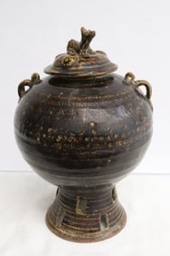 An brown glazed earthenware covered jar