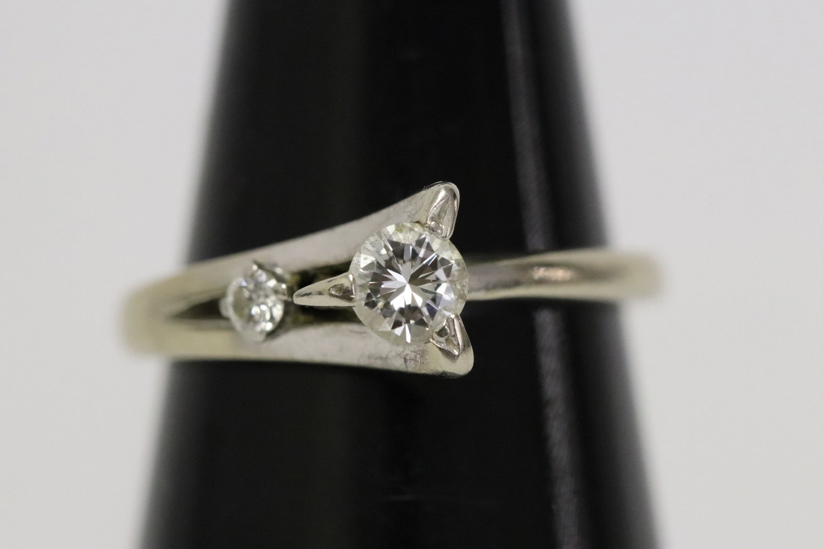 14K W/G diamond ring: 14K W/G ring, center a gem quality brilliant cut diamond wt. approx. 0.25ct in VS/ G, H quality, accented with a small diamond, wt. 2.8gm, size 6.5