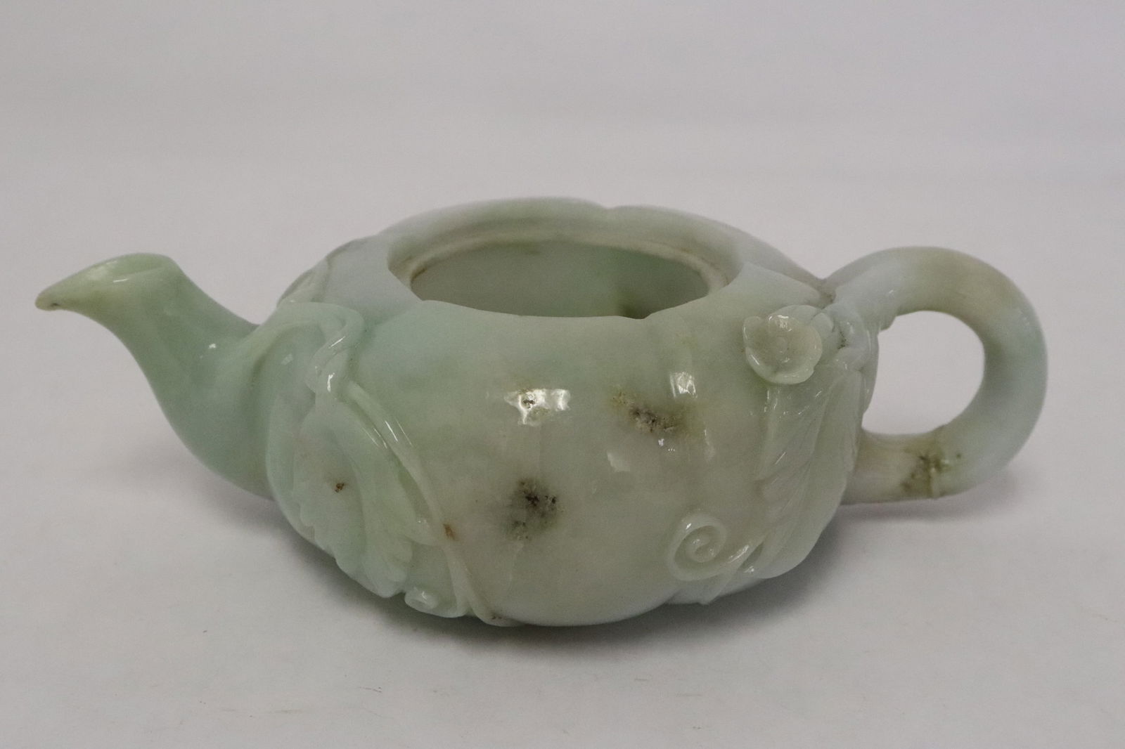 Chinese 19th century jadeite carved teapot: Very fine Chinese 19th century jadeite carved teapot with floral motif decoration in relief, missing cover, 2.15"x6.9"x4.2"