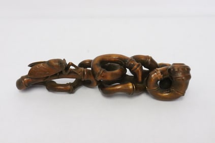 Wood carving depicting bug on bamboo branch