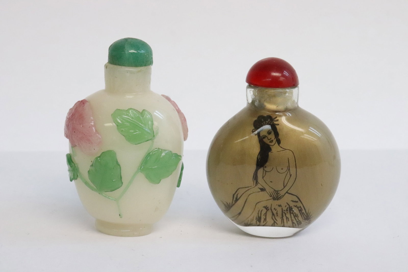 2 snuff bottles: 2 snuff bottles; an inside painted (2.3"x1.7"x0.9"), and an overlay Peking glass bottle (2.6"x1.6"x1.35")