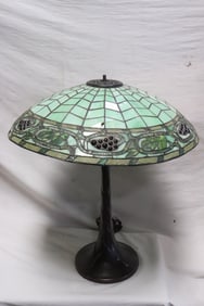 A cast metal based table lamp with leaded glass shade
