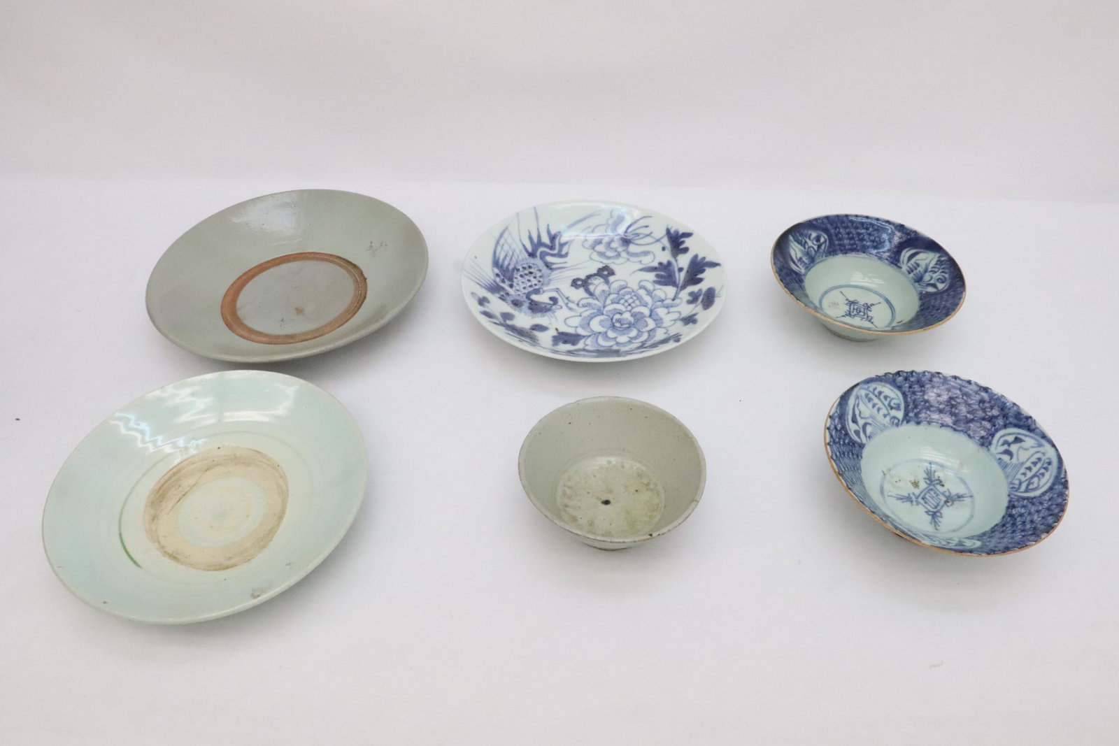 6 export porcelains: Three 17th/18th century export blue and white/ celadon porcelain plates (1.85"x9.5"dia - 2.15"x10.6"dia), and 3 export bowls (one bowl has edge chip) (2.4"x5.6"dia - 2.35"x6.2"dia)