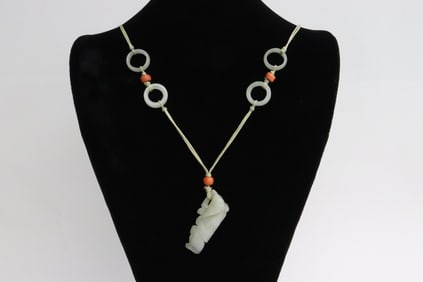 antique white jade pendant attached to a string necklace
