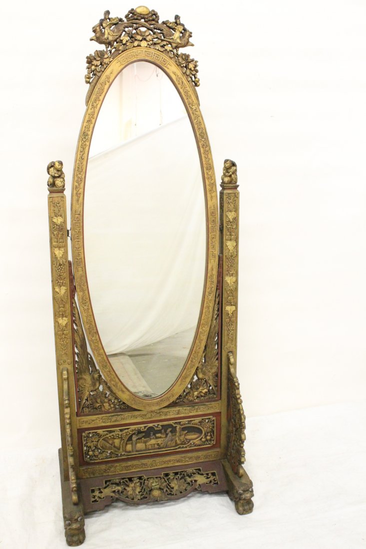 Chinese antique gilt wood floor mirror: Chinese antique gilt wood floor mirror, the frame carved with flowers and geometric pattern in relief, accented by girl and child figures, base carved with phoenix, dragon and qilin motif, 71"Hx27.5"x