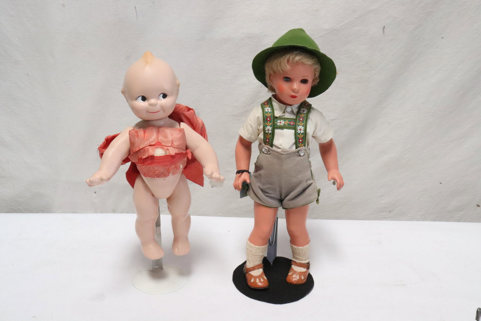 a cupid doll, and a Cathy Kruse doll: 2 dolls; a cupid doll (13.3"H), and a Cathy Kruse doll (17"H)
