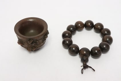 a wood bead bracelet, and a horn like carved cup