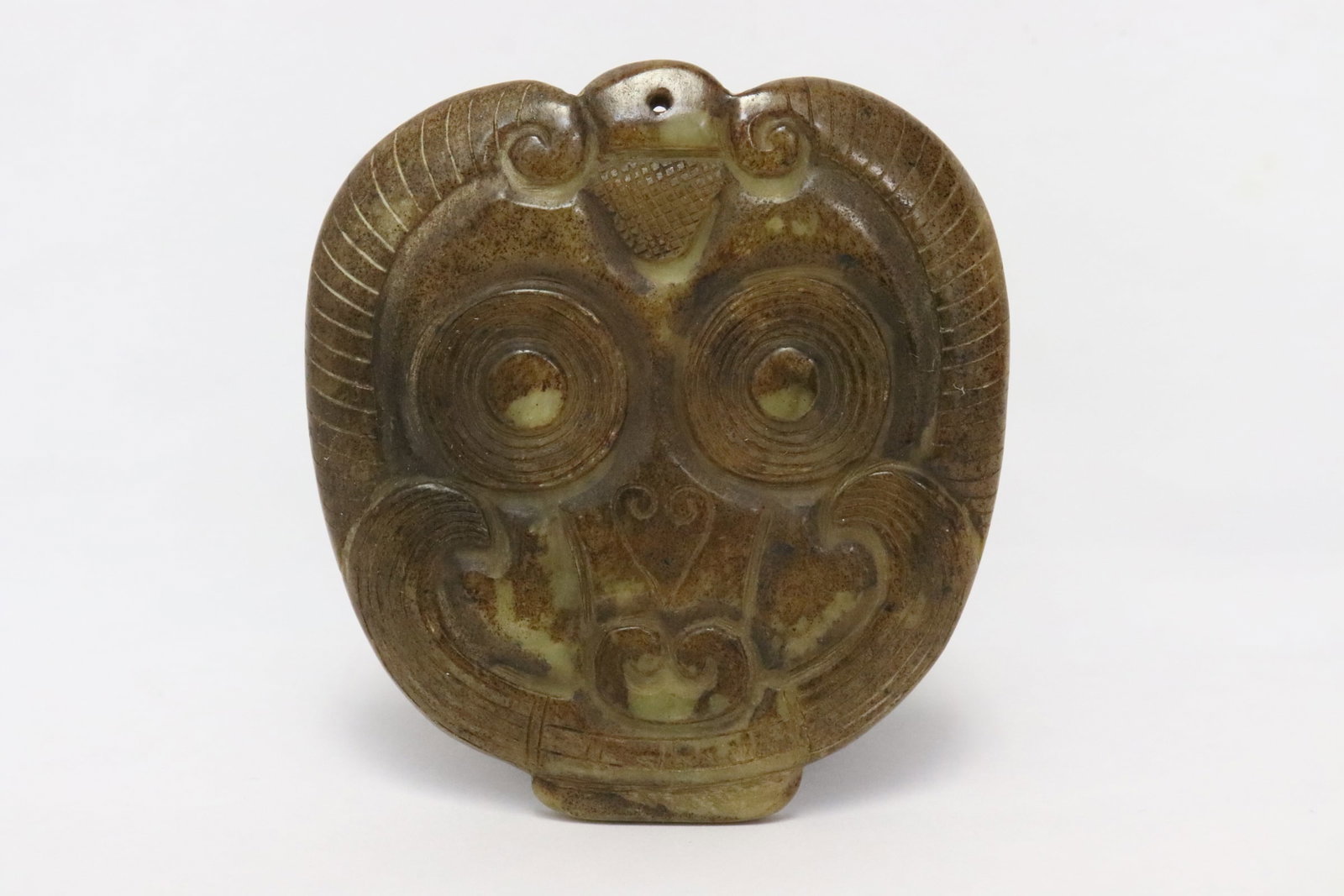 A stone carved ornament in mask motif: A stone carved ornament in mask motif, 3.3"x3.1"x0.33"