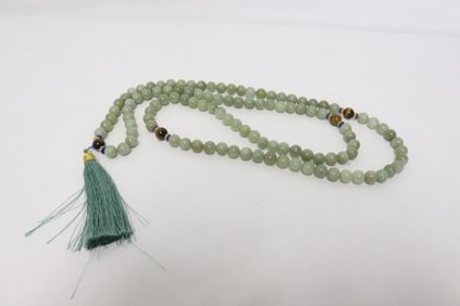 A long jade like stone carved necklace