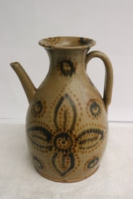 A brown on brown earthenware handled wine server