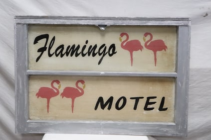 A window with Flamingo sign