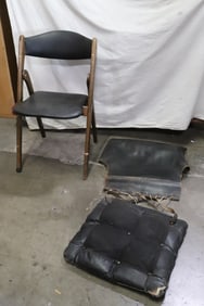 A folding chair, and leather seat, backing of a chair
