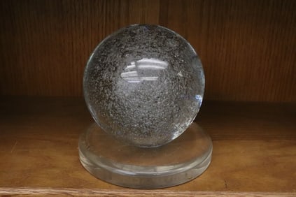 A large crystal ball with Lucite base