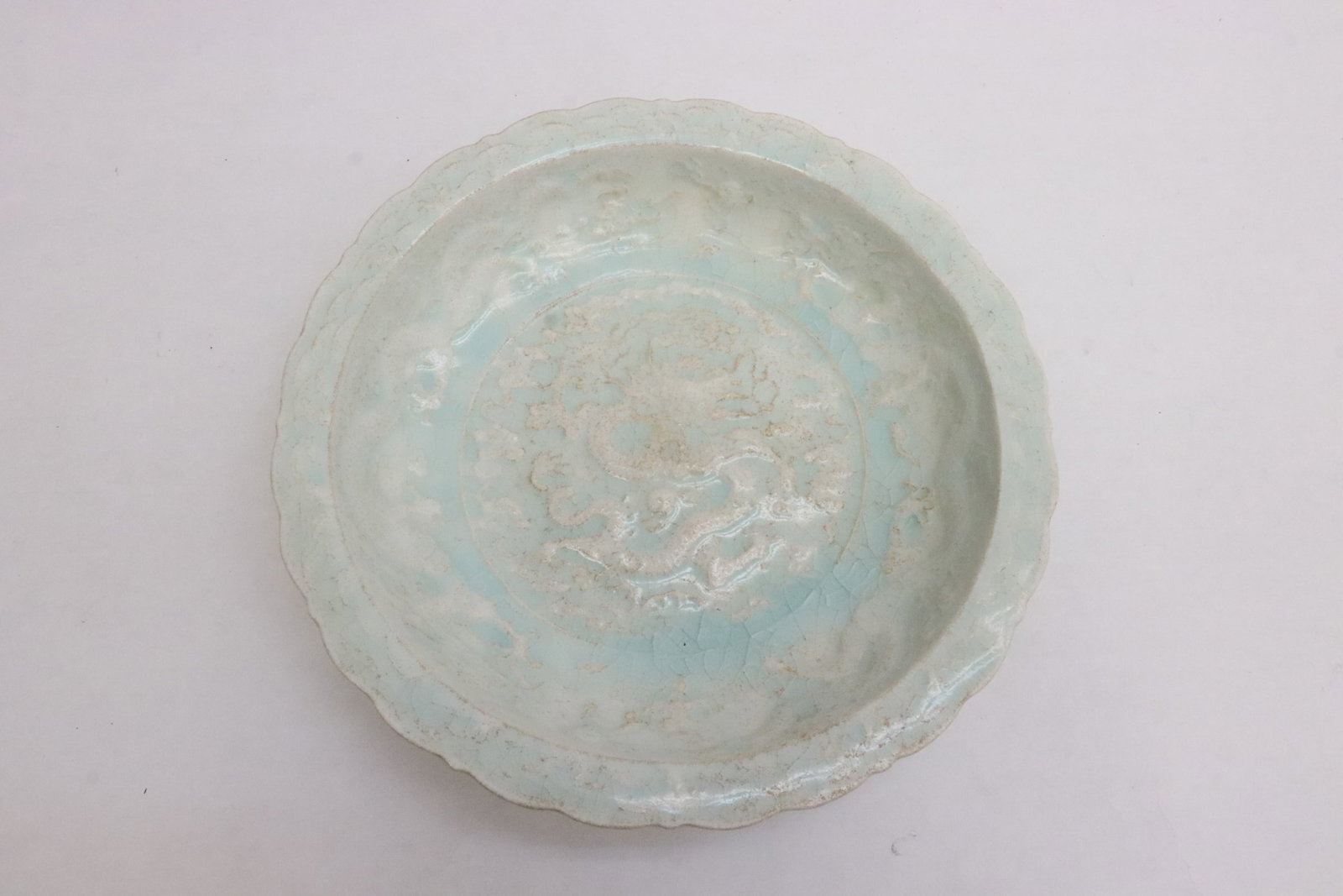 A light blue glazed porcelain plate: A light blue glazed porcelain plate embossed with dragon motif decoration, 1.65"x7.9"dia