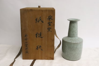 A crackleware porcelain vase in storage box