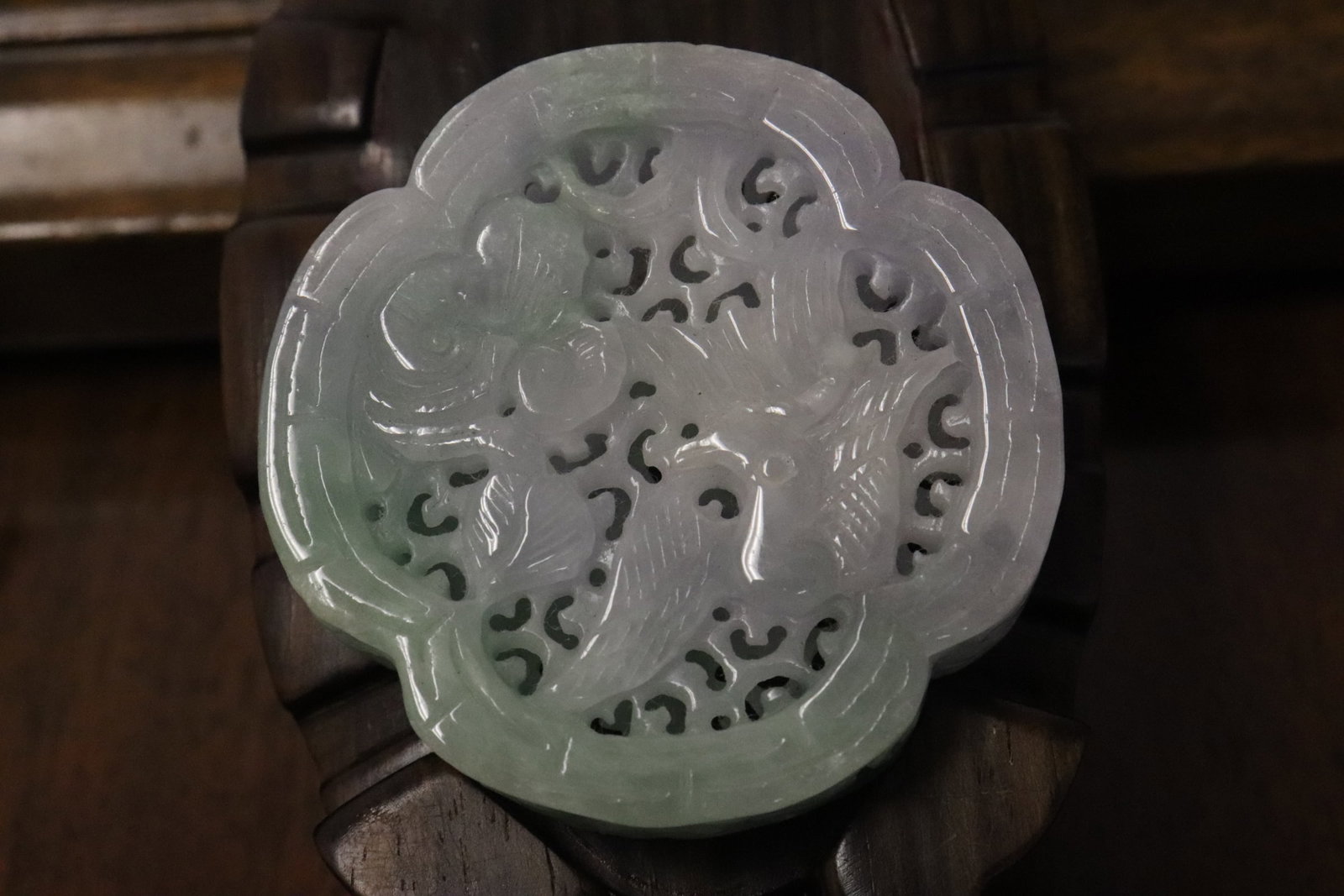 A jadeite carved ornament/ pendant: A jadeite carved ornament/ pendant in pierced style, carved on both sides to depict bird and flower motif decoration, 2.16"x2.16"x0.55"