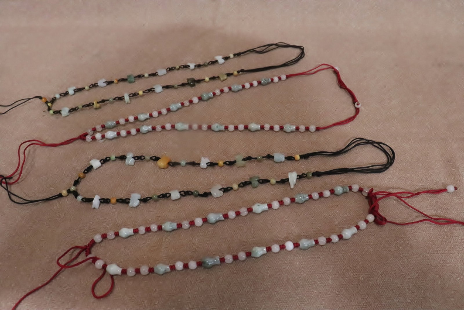 4 necklaces with stone carved beads: 4 necklaces (18"L - 25"L) with stone carved beads (0.2"x0.2"dia - 0.5"x0.5"dia)