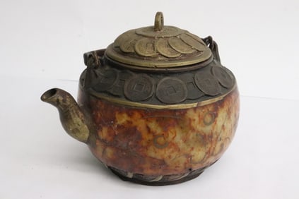A stone carved teapot with metal cover