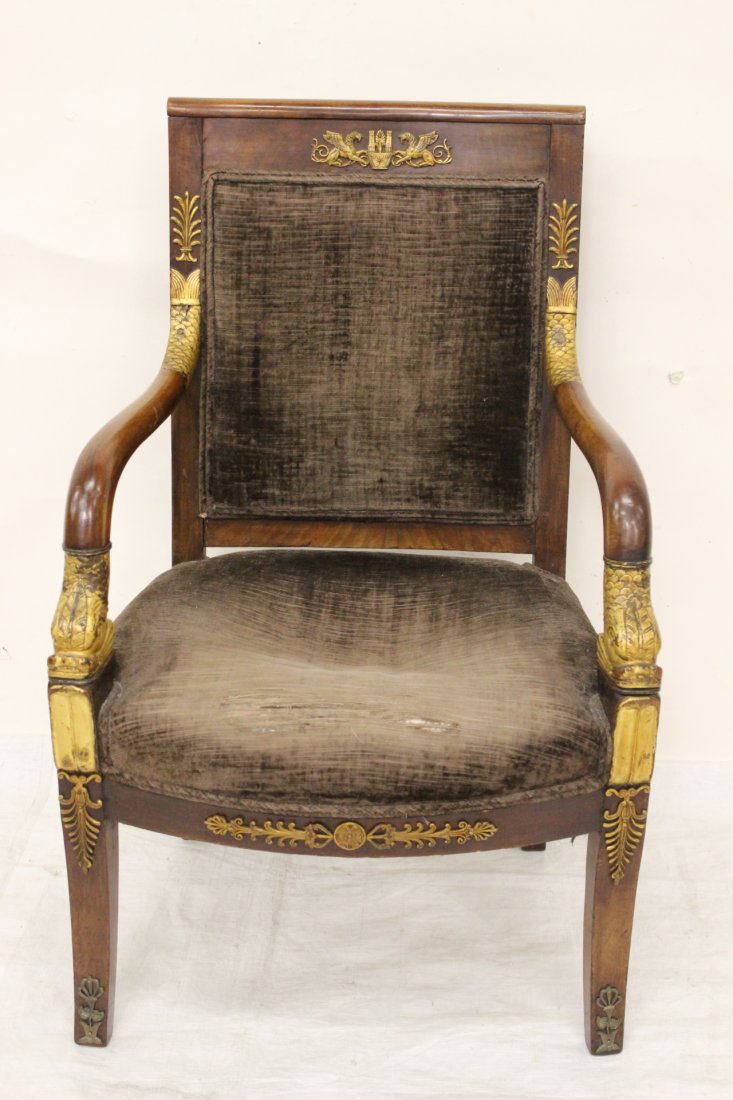 French First Empire mahogany armchair: French First Empire mahogany armchair with gilt wood decoration of dolphin, and bronze ormolu. First quarter of 19th century. Provenance: estate of Barbara Storms Harris. 36.25"Hx23"x22.75"