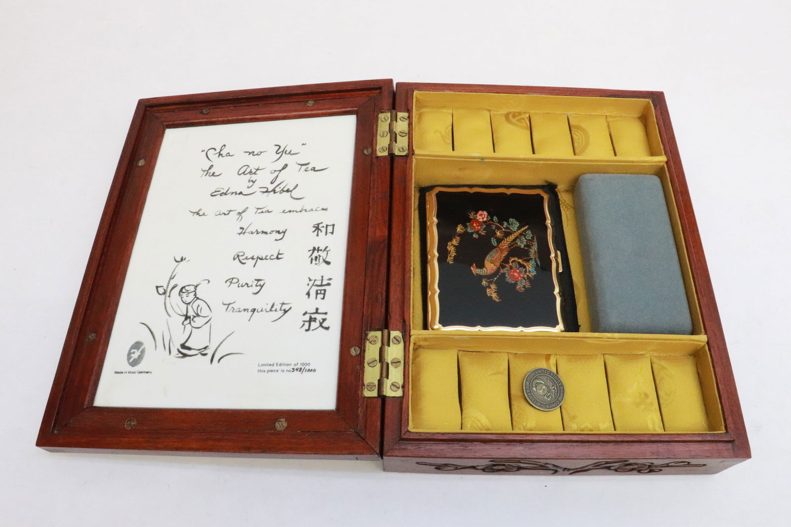 Jewelry box w/ porcelain plaque by Edna Hibel: Jewelry box (2.6"x10.4"x7.7") with limited edition porcelain plaque by Edna Hibel, with enamel cigarette compact (3.4"x4.3"x0.35") and an enamel light (3.6"x0.7"x0.3")