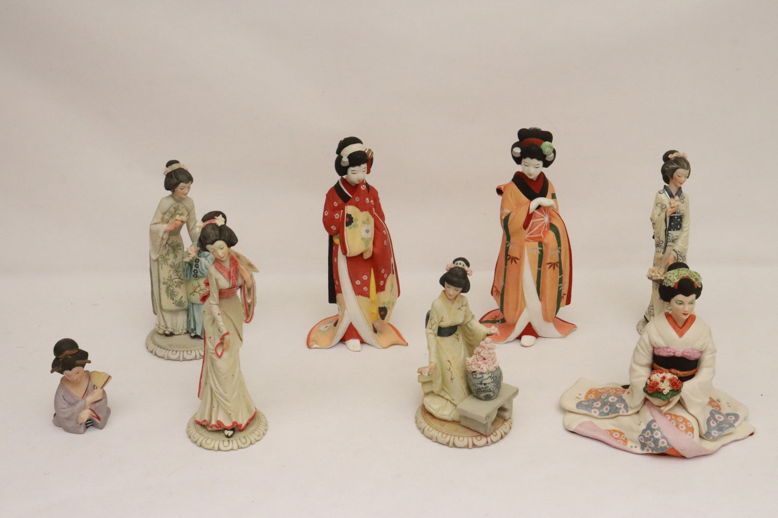 7 bisque and porcelain sculptures of Japanese ladies: 7 bisque and porcelain sculptures of Japanese ladies, 4"H - 10.5"H